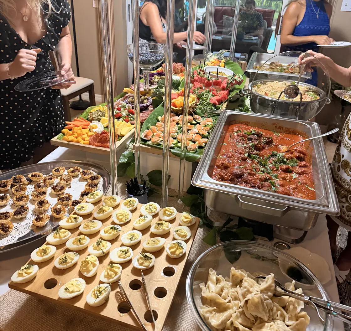 A shared table of home-cooked dishes at an APWS potluck